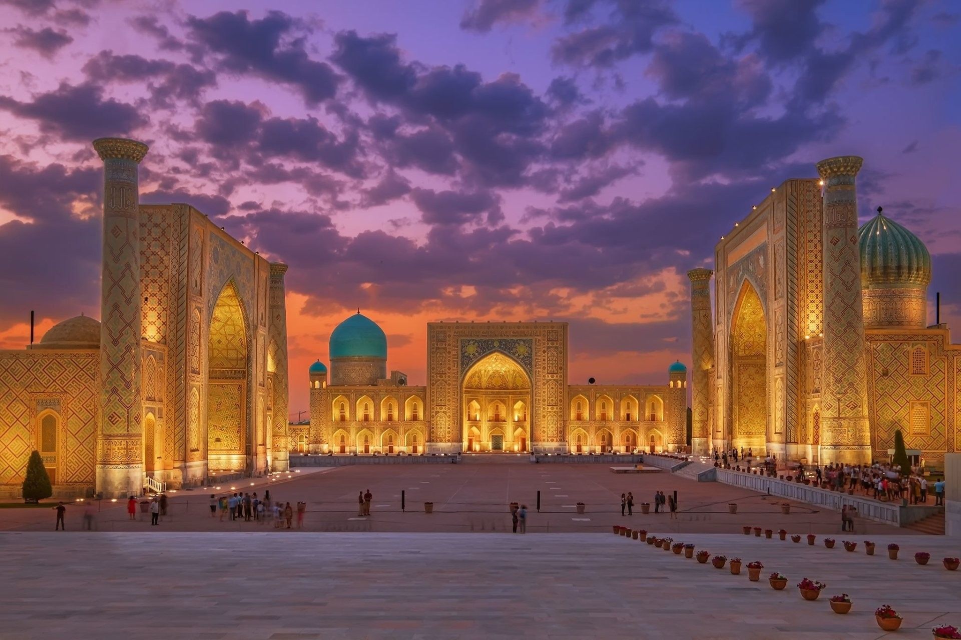 Registan Square in Samarkand beneath a purple and orange sunset sky